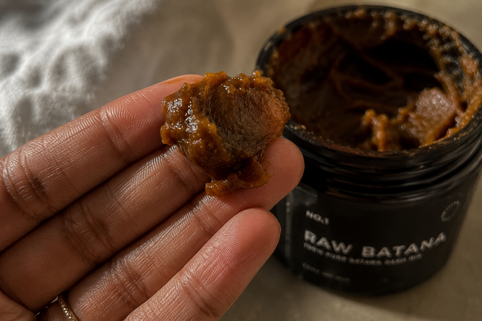 Close-up of raw batana texture on fingertips